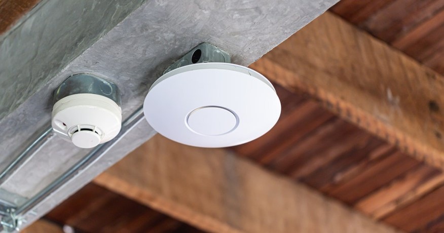 a round wifi booster mounted on the ceiling