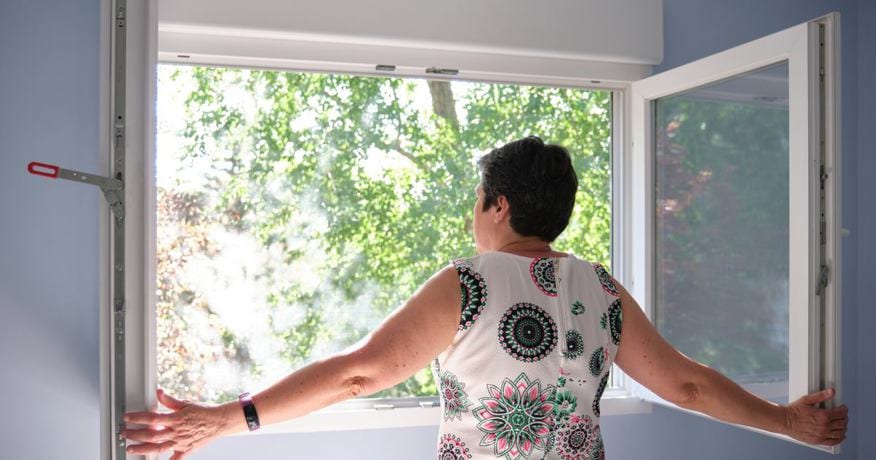 a woman opening the window to increase humidity