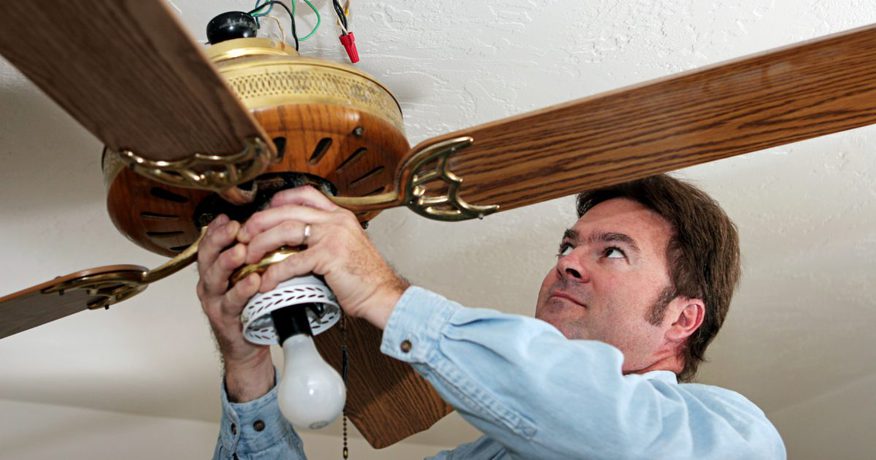 a person removing a ceiling fan