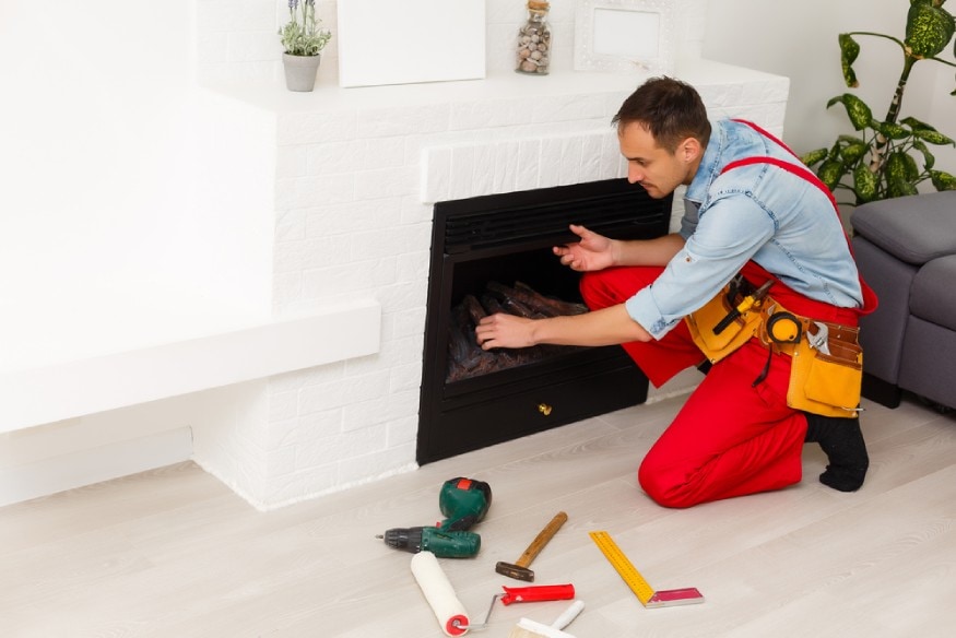 technician removing the front panel of an electric fireplace