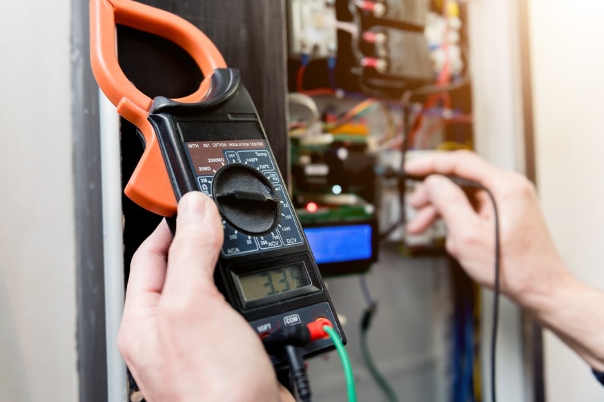 electrician using a multimeter to check the circuit breaker