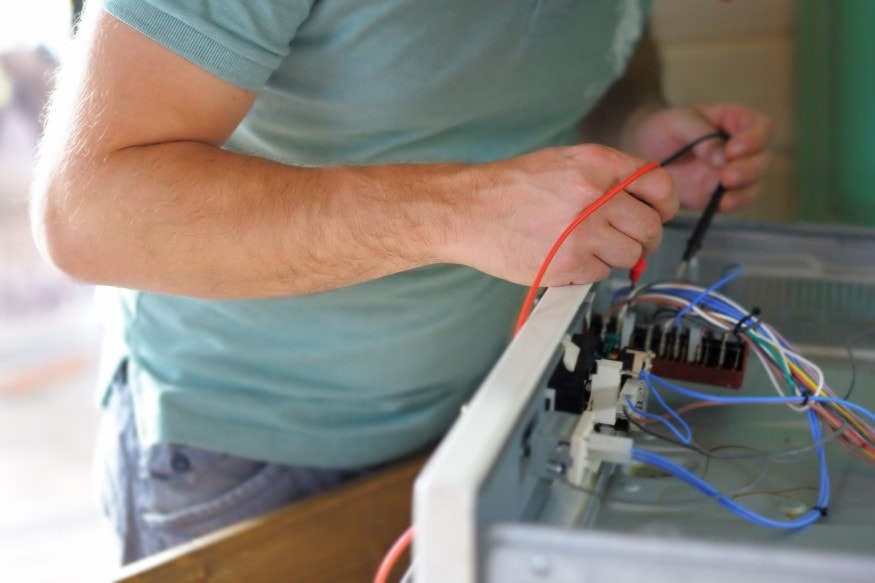 a technician checking the electrical wiring of an electric fireplace