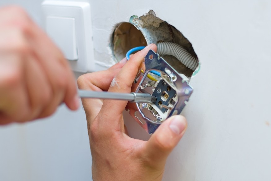 an electrician checking the electrical outlet