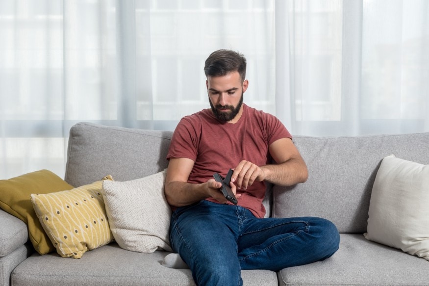 a person replacing the electric fireplace remote’s batteries